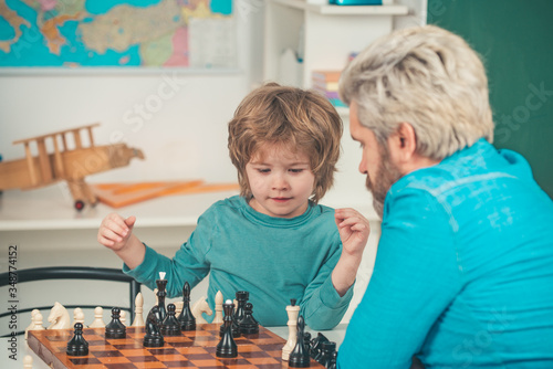 Happy Father and son. Games and activities for children. Man teacher play chess with preschooler child.