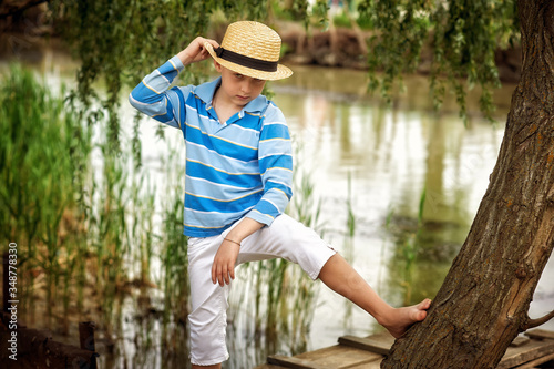 Portrait of a boy in a straw hat on the river Bank © fisher05