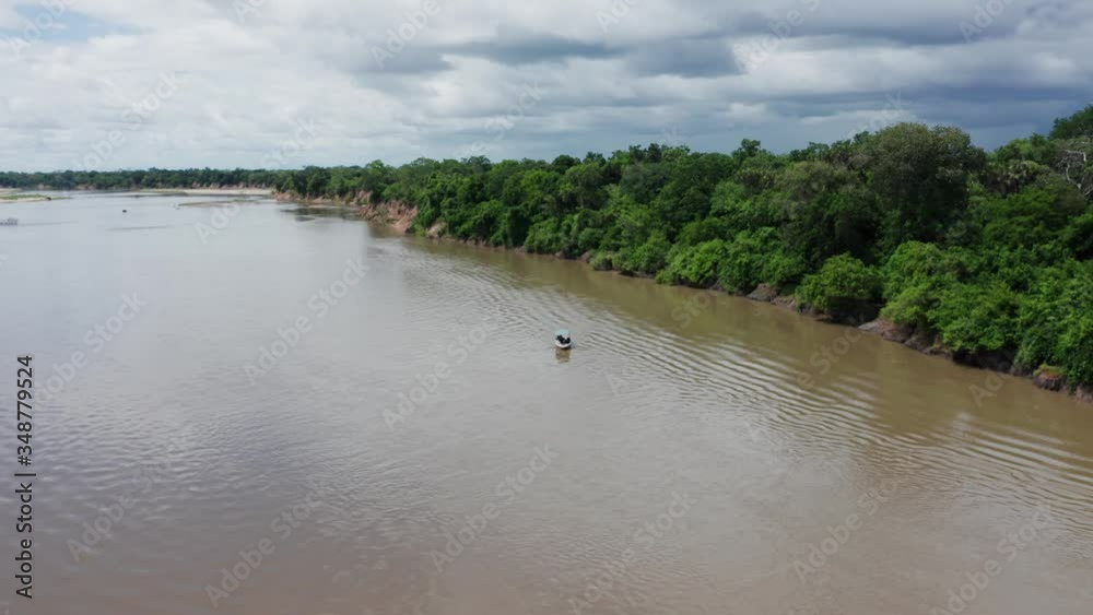 Aerial drone shot flying forward approaching a boat in a river in Selous, Tanzania. Cloudy sky. Aerial drone shot flying forward approaching a boat in a river in Selous, Tanzania. Cloudy sky.
