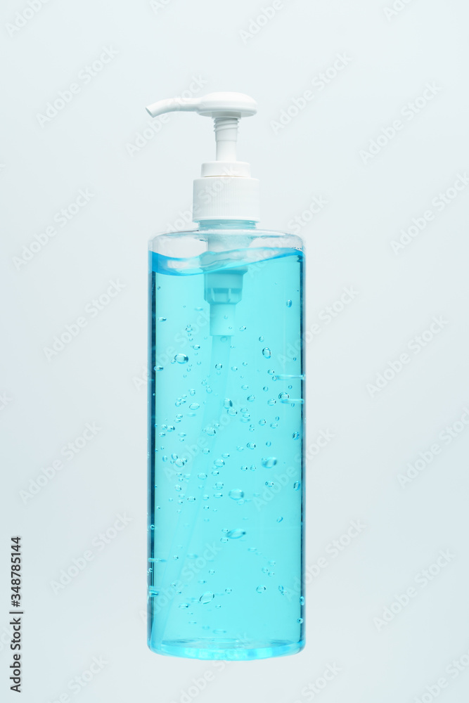 Clear blue hand sanitizer in a clear pump bottle on a white background. Clear blue hand sanitizer in a clear pump bottle on a white background.
