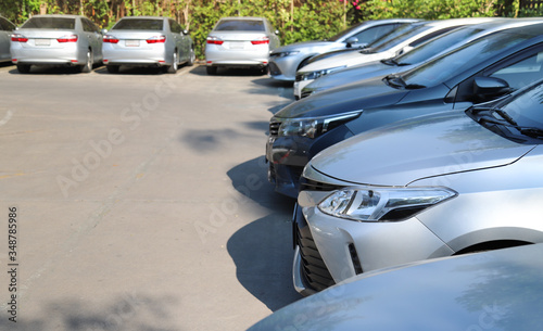 Closeup of front side of soft blue car and other cars parking in outdoor parking lot in sunny day.  © Amphon