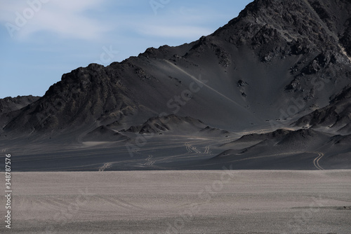 Barren mountains on rocky desert landscape and some wheel ruts