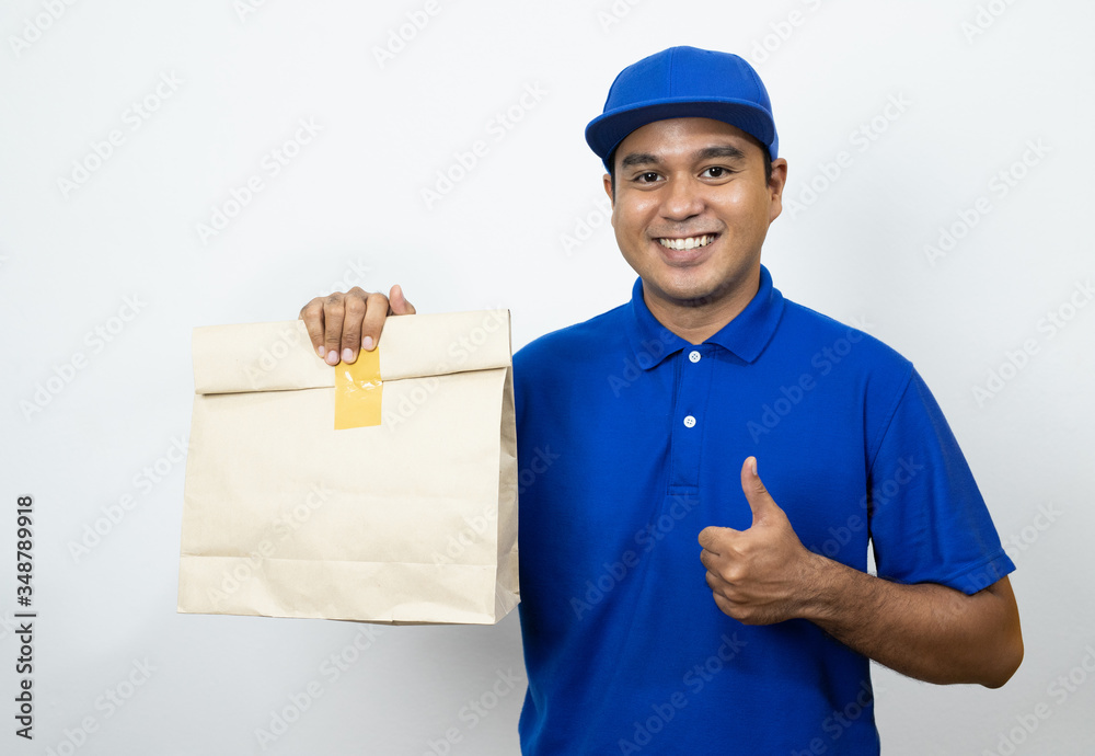 Delivery man blue uniform holding paper bag on isolated white background. Delivery man blue uniform holding paper bag on isolated white background.