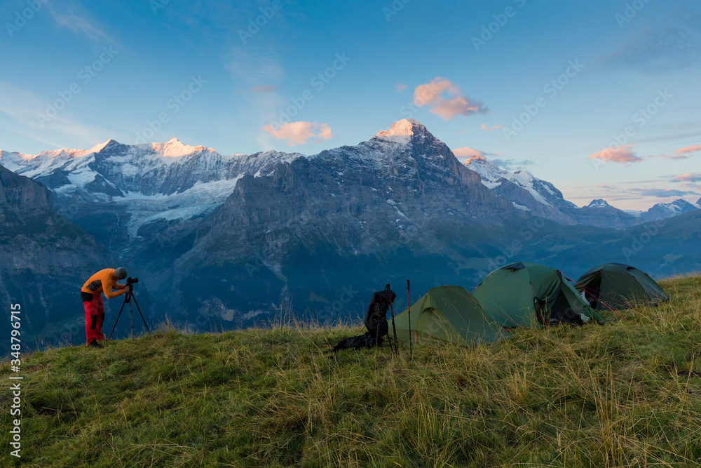 Alpine valley glowing by sunlight. Popular tourist attraction. Dramatic and picturesque scene with tents. Location place in Swiss alps, Grindelwald, Bernese Oberland, Europe. Beauty world. Eiger