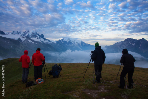 Photographers stay on lake and takes photos. Dreamy mountains, orange sunrise in a beautiful valley. Colorful summer view of the Lac Blanc lake with Mont Blanc (Monte Bianco), Alps on background.