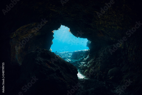 Underwater scene with tunnel cave in blue ocean