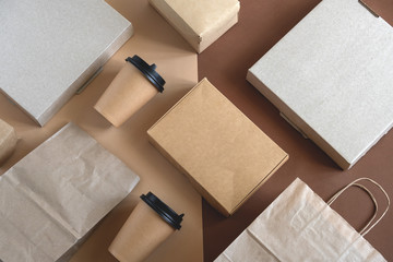 top view flat lay disposable blank delivery food packaging on a beige and brown background