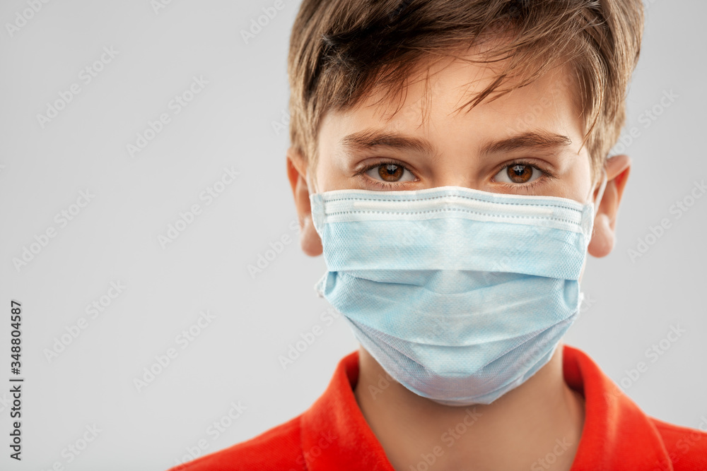 health protection, safety and pandemic concept - close up of boy in protective medical mask over grey background health protection, safety and pandemic concept - close up of boy in protective medical mask over grey background