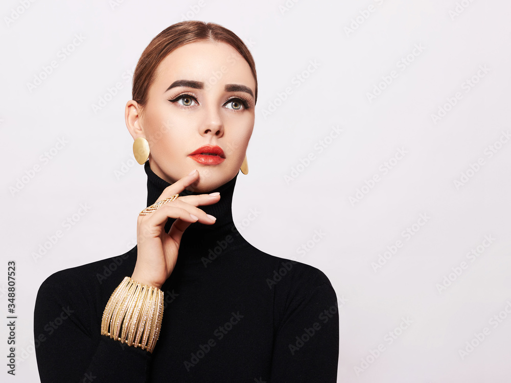 Art portrait of a beautiful, elegant woman in a black turtleneck and gold jewelry Art portrait of a beautiful, elegant woman in a black turtleneck and gold jewelry