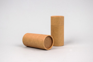 Paper tubes on grey background with copyspace - cardboard packaging for natural cosmetics and deodorant. Reusable packaging and recycling concept. Mockup