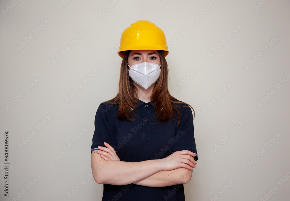 The Worker woman with helmet wears a protective antivirus mask such as coronavirus covid-19 or sars The Worker woman with helmet wears a protective antivirus mask such as coronavirus covid-19 or sars