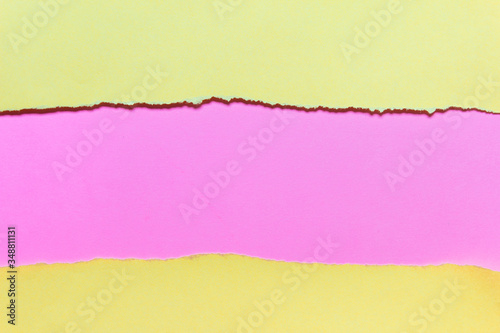 Yellow and pink paper layers with ripped uneven edges. Photo with copy blank space.