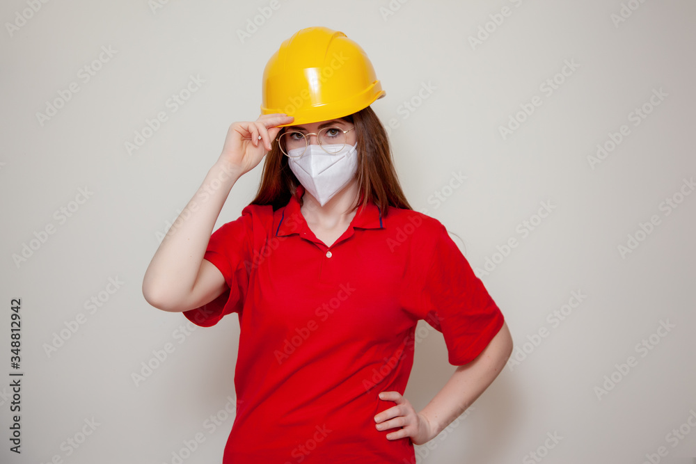 The Worker woman with helmet wears a protective antivirus mask such as coronavirus covid-19 or sars The Worker woman with helmet wears a protective antivirus mask such as coronavirus covid-19 or sars
