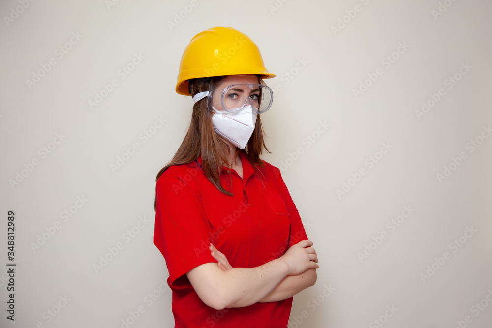 The Worker woman with helmet wears a protective antivirus mask such as coronavirus covid-19 or sars The Worker woman with helmet wears a protective antivirus mask such as coronavirus covid-19 or sars
