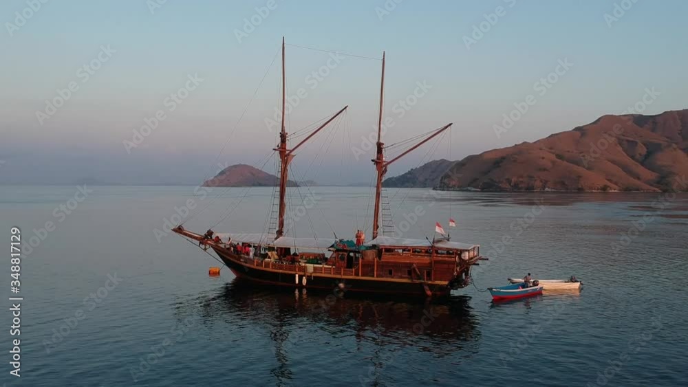 Drone, Komodo National Park dive boat at sunset surrounded by islands Drone, Komodo National Park dive boat at sunset surrounded by islands
