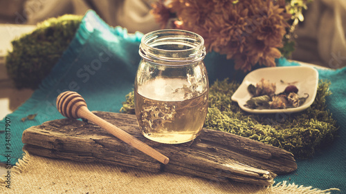 A jar of honey, dry flowers and leaves for the preparation of natural herbal tea from the autumn cold. Natural remedy of traditional medicine. Banner