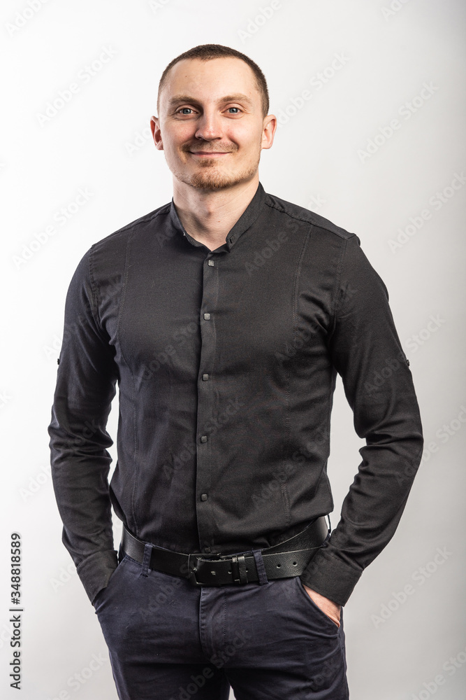 Young smiling man in a black shirt on a light background Young smiling man in a black shirt on a light background