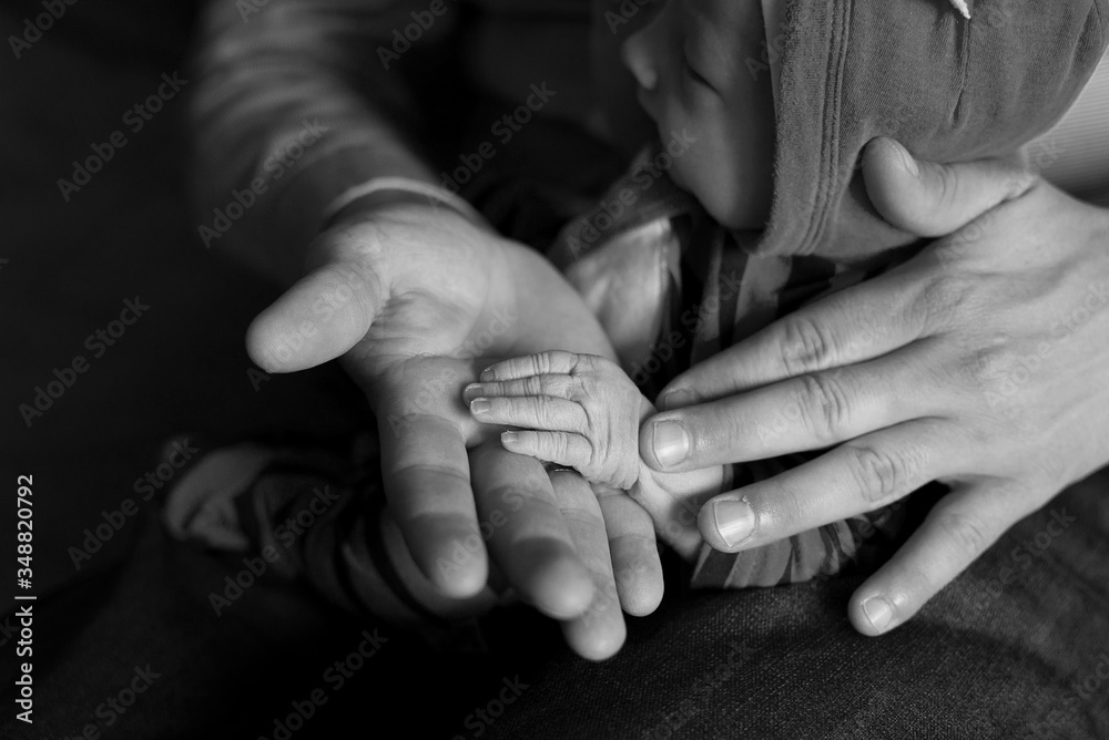 Father and baby hands. Baby’s hand in dad’s hand, black and white photo. Father and baby hands. Baby’s hand in dad’s hand, black and white photo.