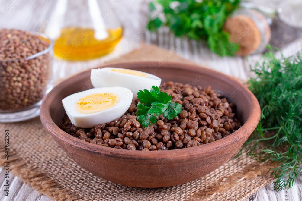Boiled lentils with egg in ceramic bowls on a wooden background Boiled lentils with egg in ceramic bowls on a wooden background