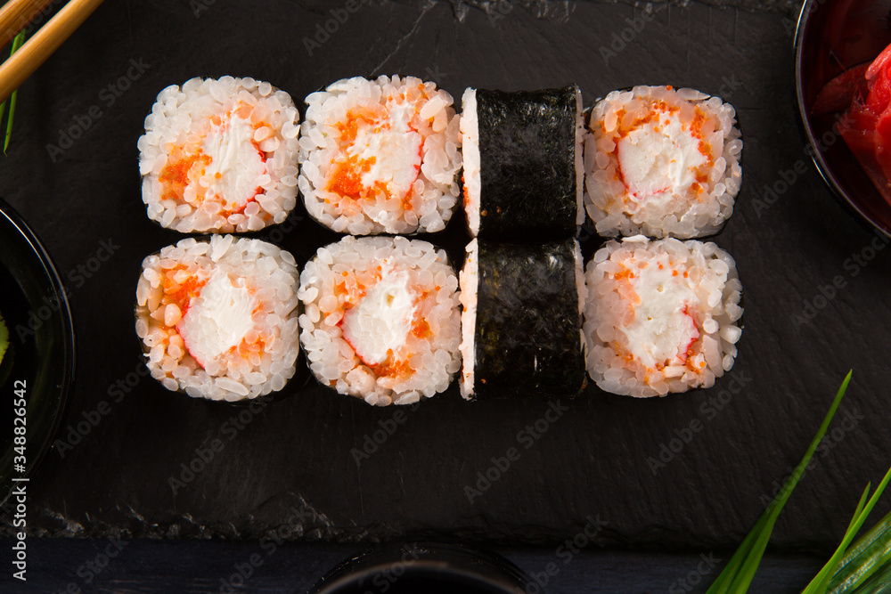 Set of sushi rolls with wasabi and ginger on a black background. Japanese oriental cuisine Set of sushi rolls with wasabi and ginger on a black background. Japanese oriental cuisine