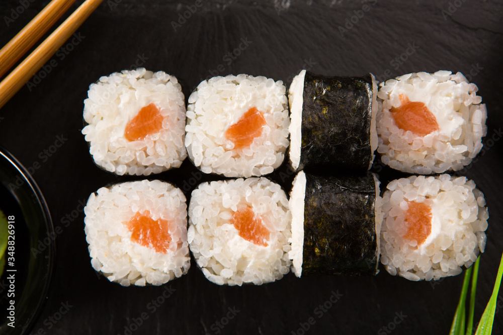 Set of sushi rolls with wasabi and ginger on a black background. Japanese oriental cuisine Set of sushi rolls with wasabi and ginger on a black background. Japanese oriental cuisine