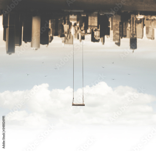 surreal swing hanging upside down compared to the metropolis