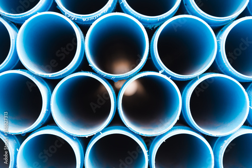 Blue plastic pipes stacked in rows. look inside the pipe. Background, texture.
