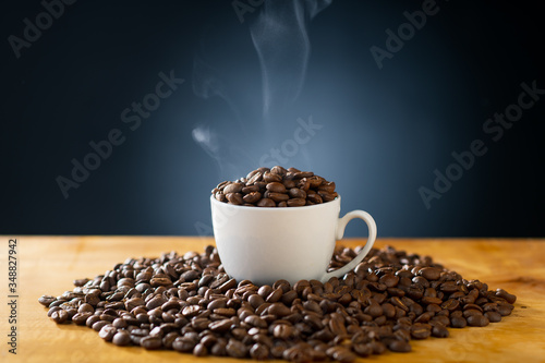 Roasted coffee beans in coffee cup. Delicious coffee concept image.