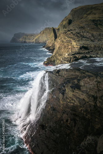 Waterfall and sea cliffs of Faroe Islands.