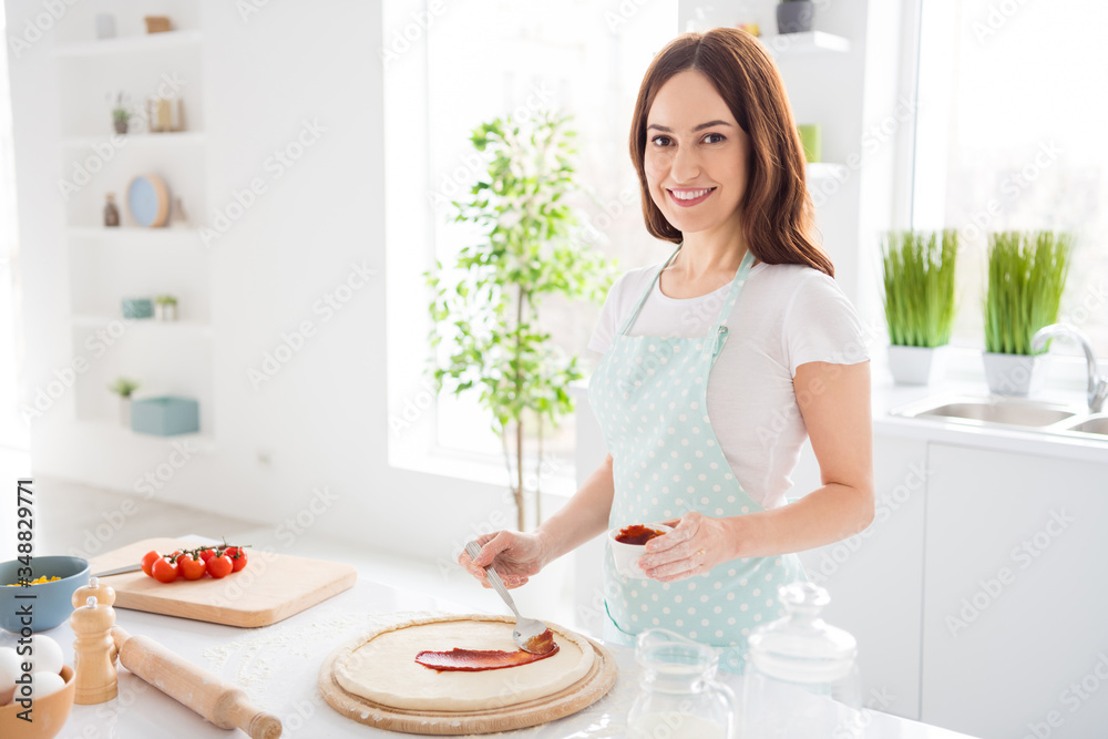 Photo of beautiful cheerful housewife enjoy hobby preparing family recipe dinner forming making dough for italian pizza quarantine time stay home modern kitchen indoors