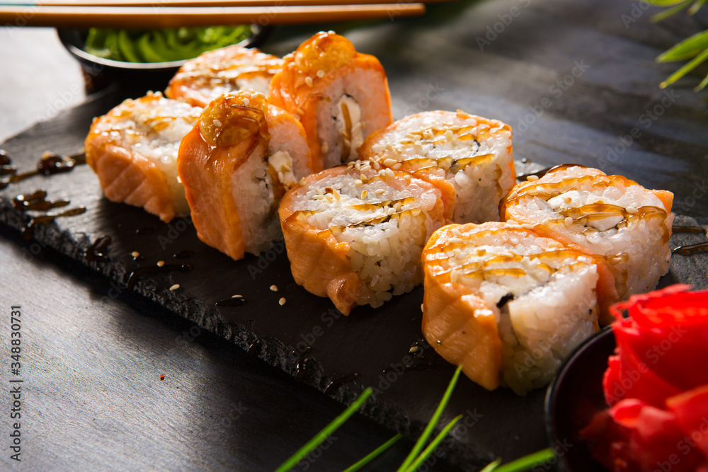 Set of baked sushi rolls with wasabi and ginger on a black background. Japanese oriental cuisine Set of baked sushi rolls with wasabi and ginger on a black background. Japanese oriental cuisine