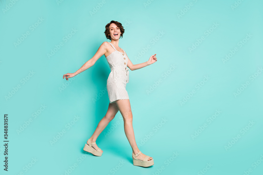 Full size profile photo of funny cheerful lady enjoy sunny day good mood walk down street wear casual summer dotted overall open toe shoes isolated pastel teal color background Full size profile photo of funny cheerful lady enjoy sunny day good mood walk down street wear casual summer dotted overall open toe shoes isolated pastel teal color background