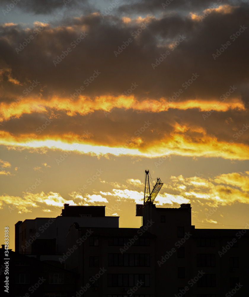 Clouds at sunset on the background of a crane