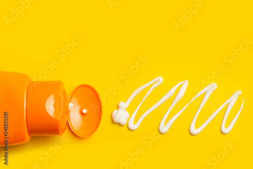 Foto Protector solar sobre un fondo amarillo liso y brillante con crema sobre el fondo