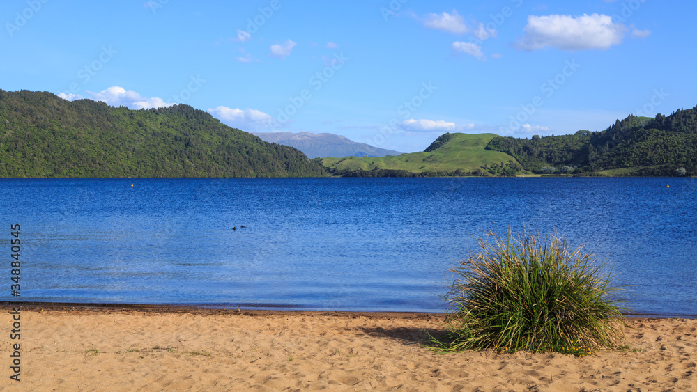 Sandy beach on Lake Okareka in the scenic Rotorua Lakes area, New Zealand