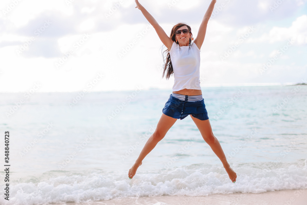 Obraz premium Young fashion woman in green dress on the beach