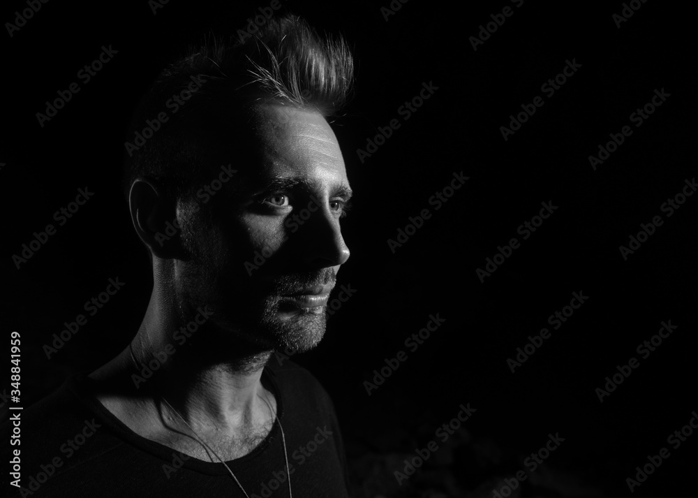 Portrait of handsome male person on black background