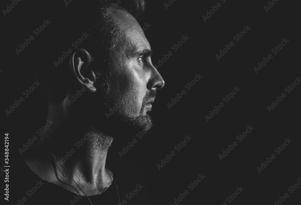 Dramatic profile portrait of male person on dark background