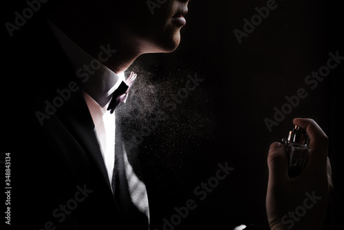 the image of a man's profile, the man sprays perfume on herself Squirting on the neck