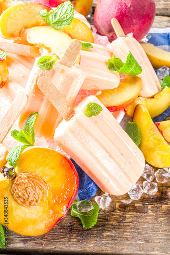 Homemade peach popsicles, fruity lollypop non-dairy vegan gelato, on grey old wooden background copy space top view