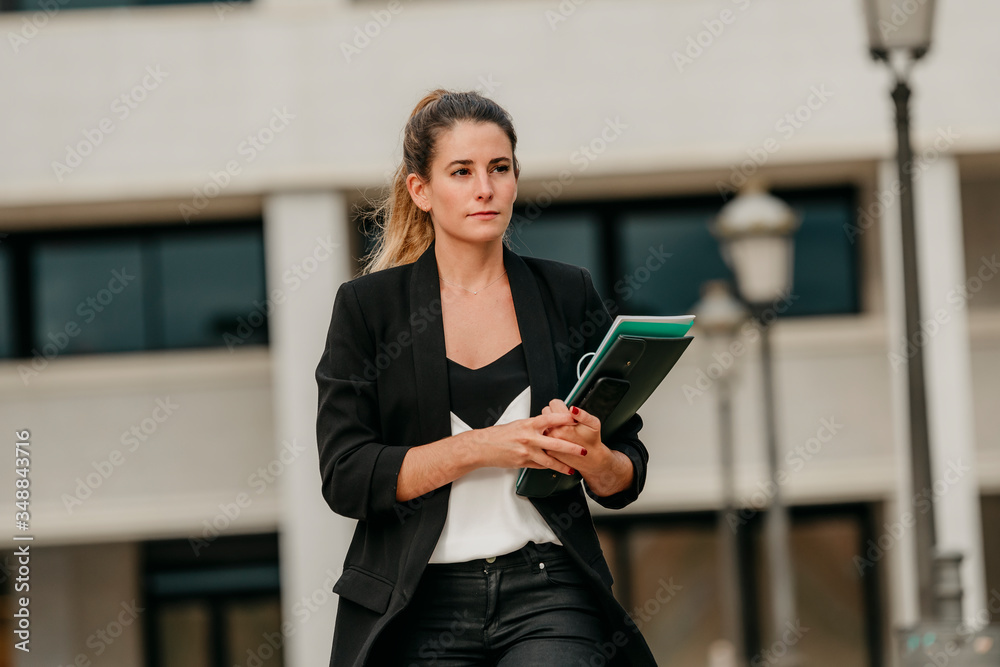 young executive woman goes to office to work walking down a street young executive woman goes to office to work walking down a street