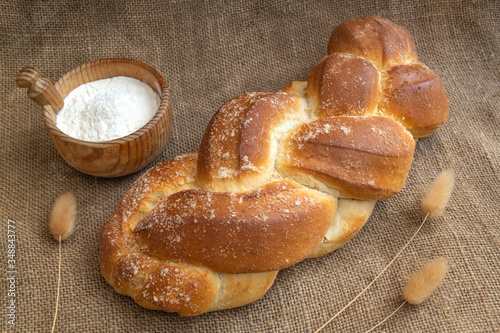 homemade kalach with a wooden plate made of wood with flour photo