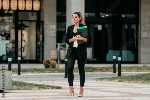 young executive woman goes to office to work walking down a street