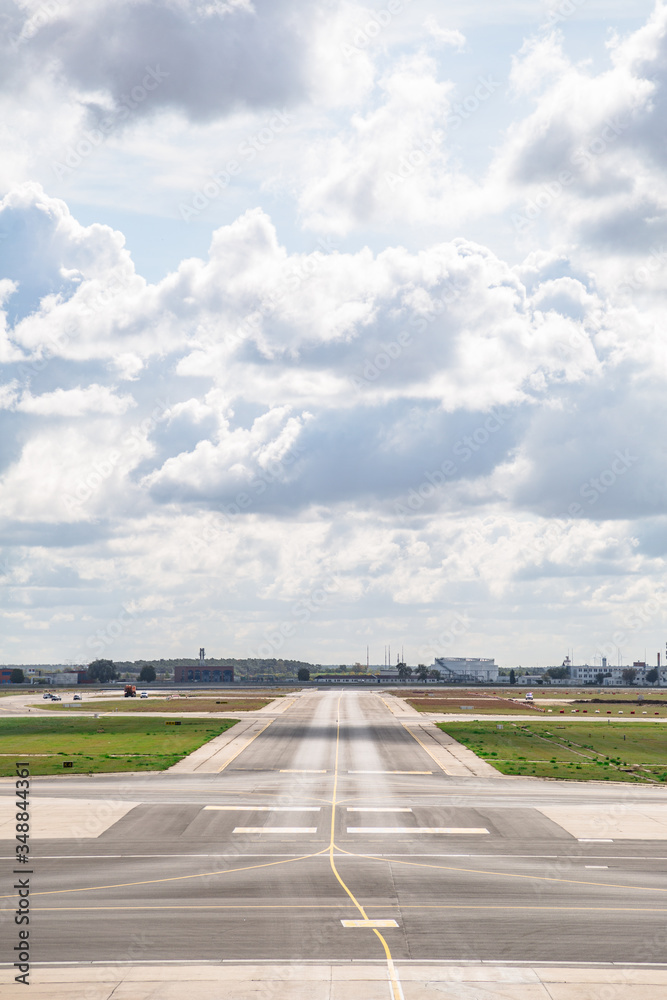 Empty airport runway with markings in cloudy day