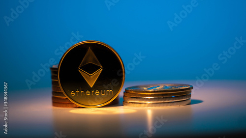 Gold moning coin Etherium on white surface with blue gradient background photo