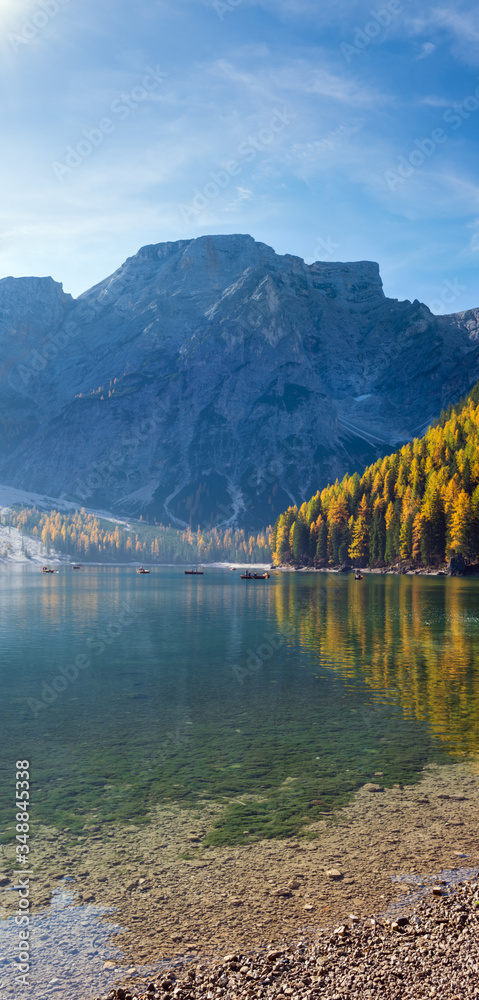 Fototapeta premium Autumn peaceful alpine lake Braies or Pragser Wildsee, South Tyrol, Dolomites Alps, Italy, Europe. Picturesque traveling, seasonal and nature beauty concept scene. People unrecognizable.