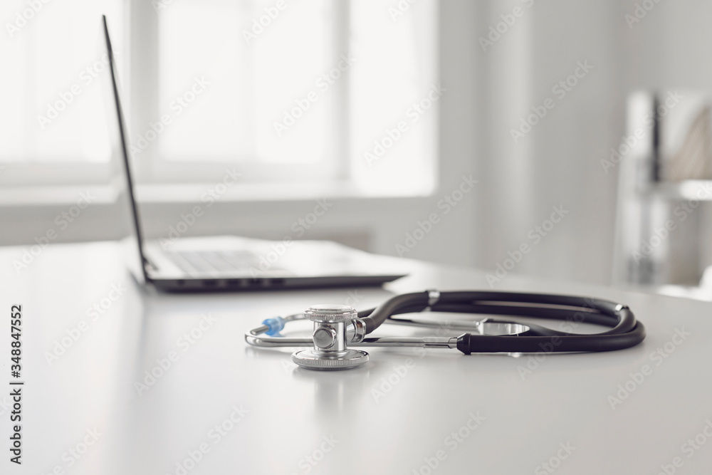 Online doctor call concept. Telemedicine. Stethoscope and laptop on a white table.