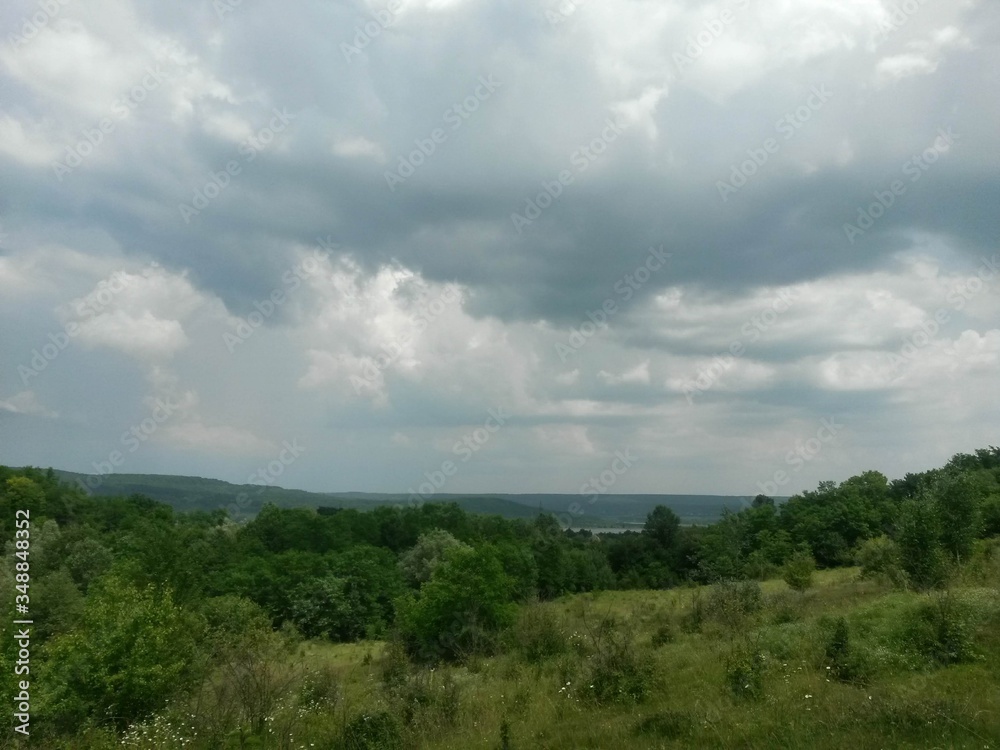 stormy clouds over green forest in summer season stormy clouds over green forest in summer season