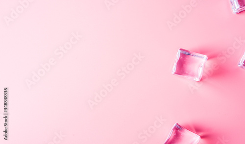 Ice cubes on pink background with space.