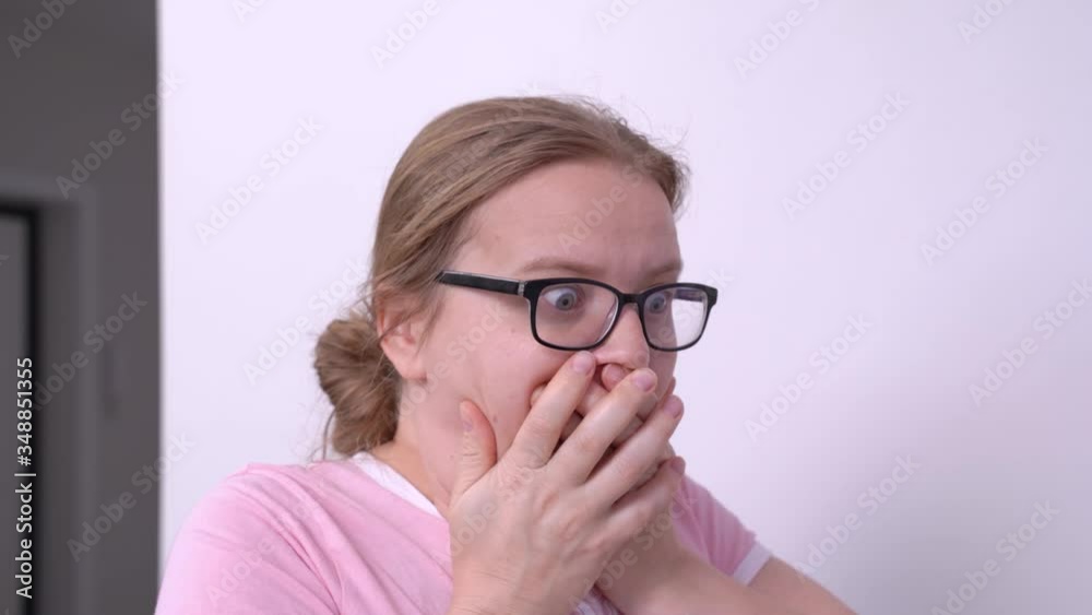 Young attractive Caucasian woman makes face of utter amazement or shock expression, opening her mouth and covering it with both hands. Wow, horrible unexpected situation, big problem emotions